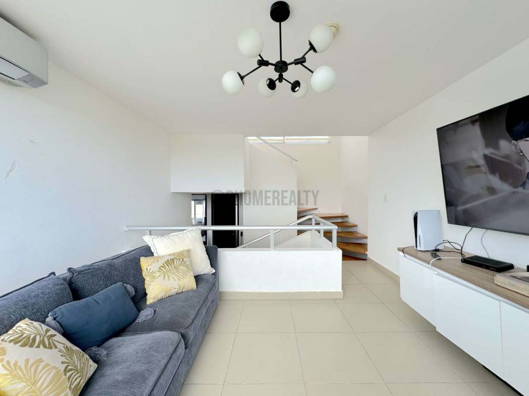 Cozy living room with TV setup, gray sofa, bright style Costa Sur Panama