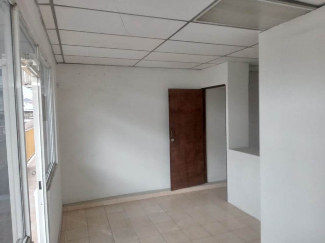 Empty interior office space with tiled floors, white walls and drop ceiling for rent in 24 de Diciembre Panama City