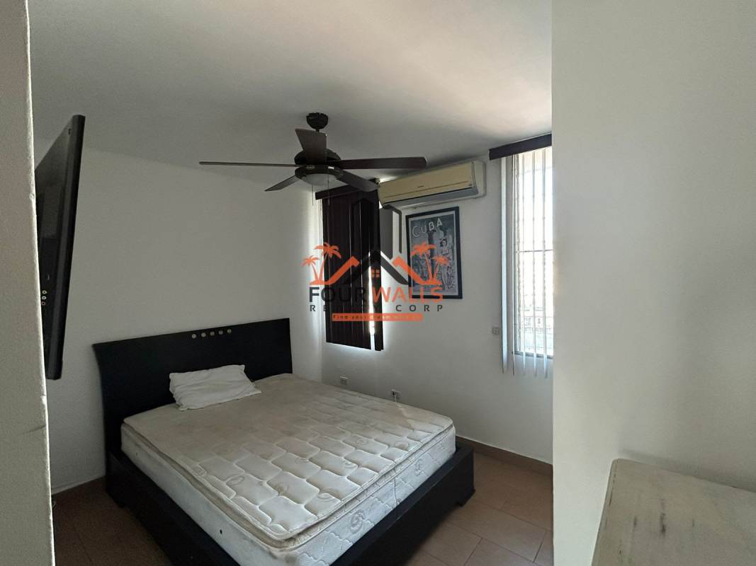 Minimalist bedroom with ceiling fan and natural light PH Mediterráneo Panama City