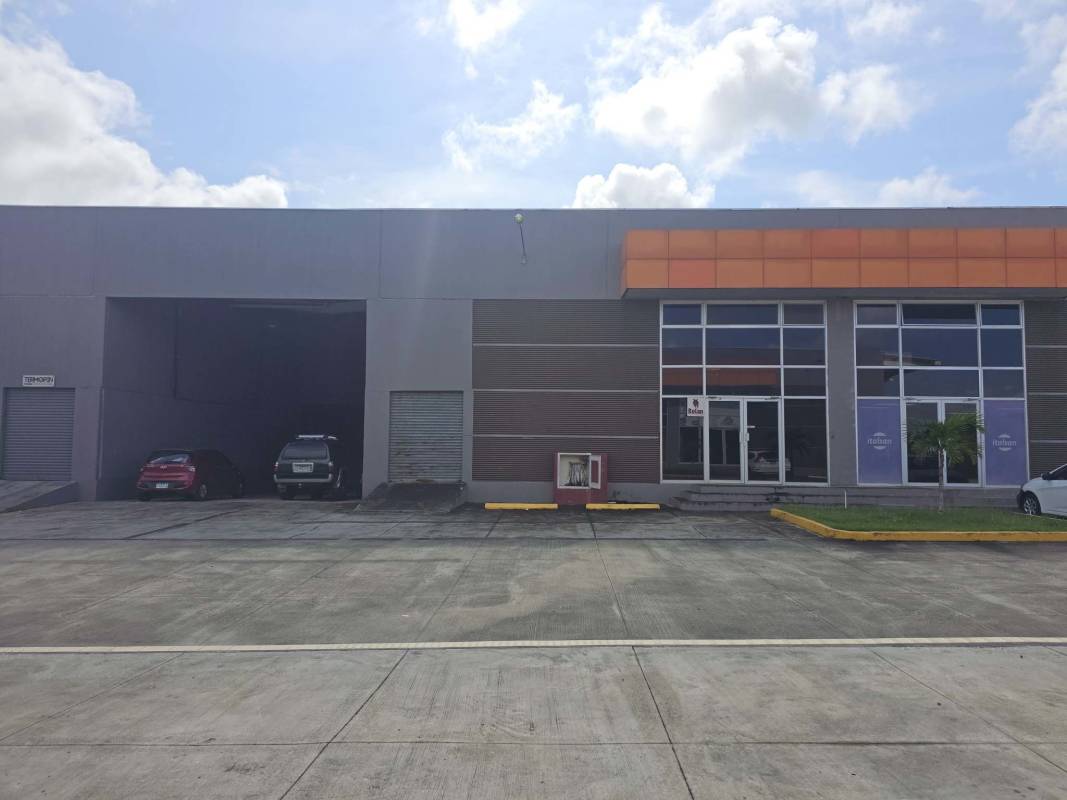 Facade of modern commercial warehouse with garage doors and parking at Pacora Panama