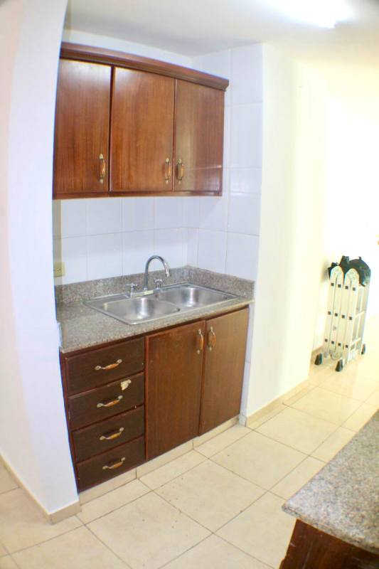 Apartment kitchen with granite countertops wood cabinets tile floor PH Villa de las Fuentes Panama