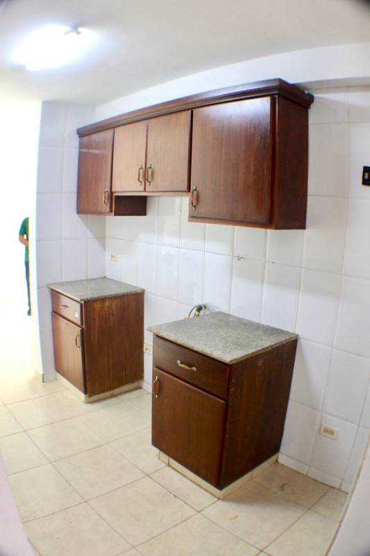 Compact kitchen space with wood cabinetry granite counters tile floor Villa de las Fuentes Panama