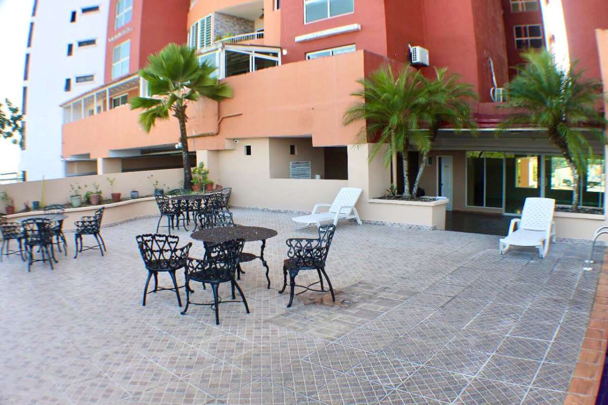 Patio outdoor dining tables chairs palm trees in PH Villa de las Fuentes Panama City Panama