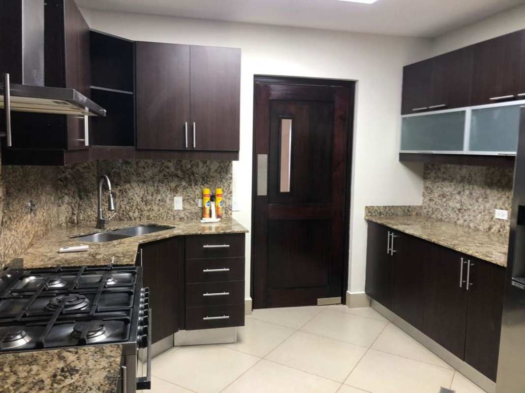 Luxury kitchen with granite island, wooden cabinets and stainless appliances Casco Viejo Panama