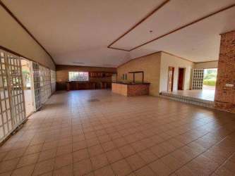 Open concept living kitchen area ceramic tiles, brick accents, glass sliding doors in Golf Club Coronado house Panama