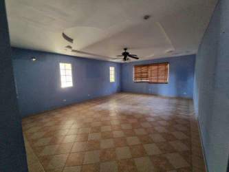 Large living room with tiled flooring, blue feature wall, windows with natural light in Coronado Golf Resort Panama