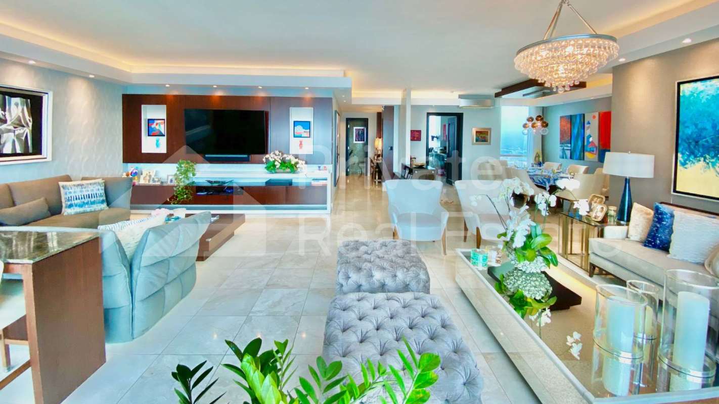 Open plan dining and living space with marble floors and large ocean view windows at PH Ocean Two Costa del Este Panama