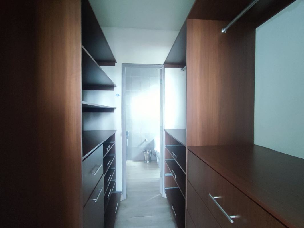 Empty modern bedroom with large windows, city skyline and built-in closets at PH Harmony Tower