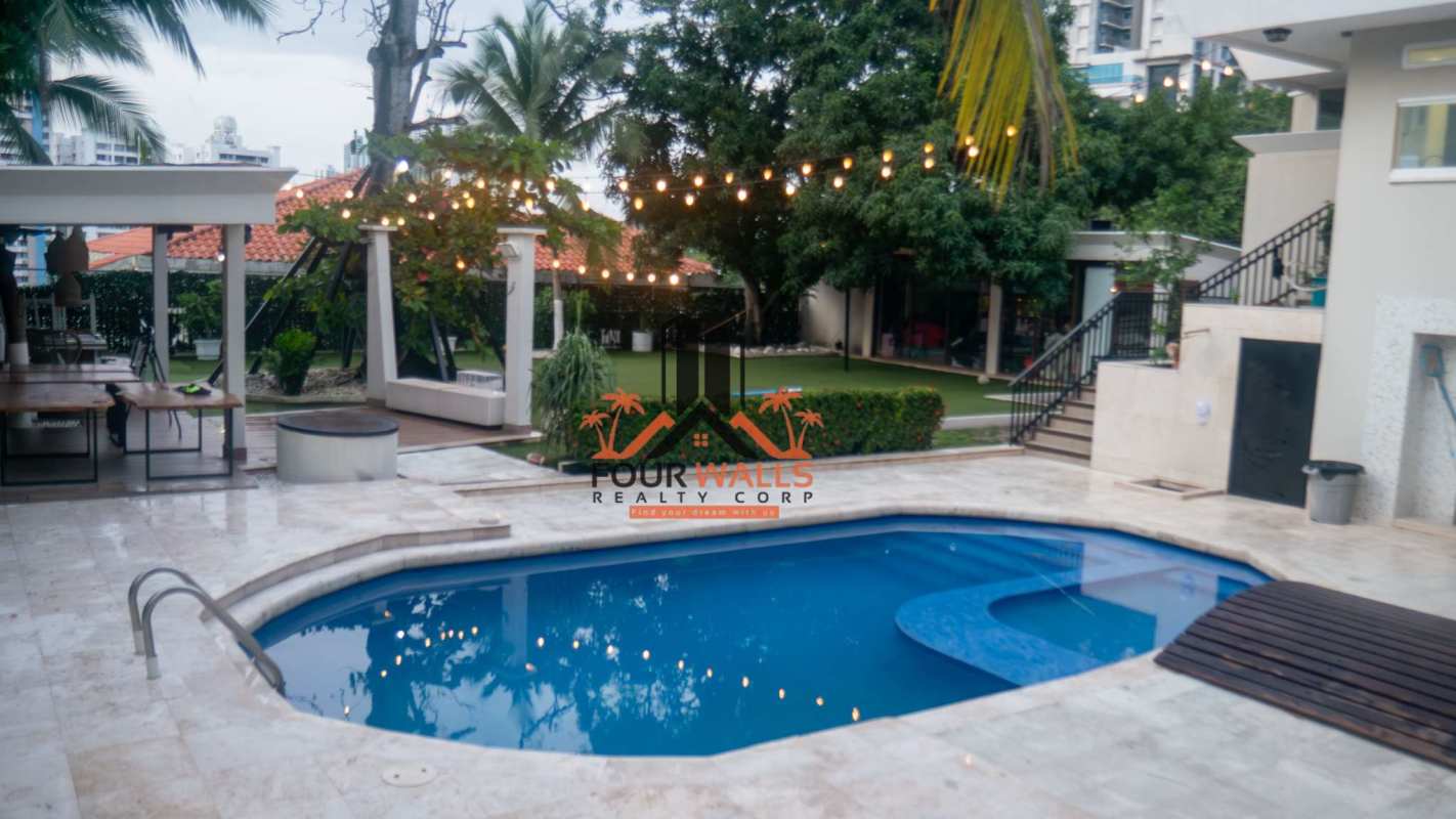 Modern pool surrounded by artificial lawn and garden at luxury mansion in Dos Mares Betania Panama