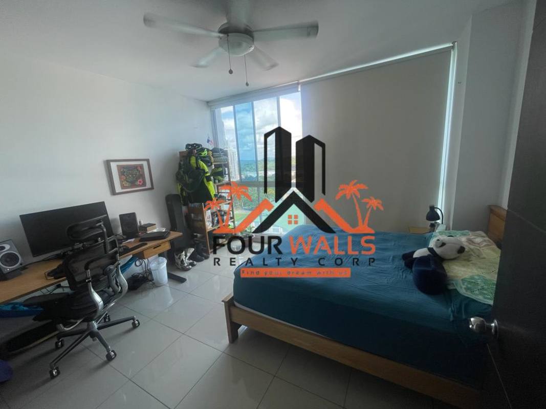 Bright bedroom with large window, wooden furniture, AC and ceiling fan in PH Forum Panama