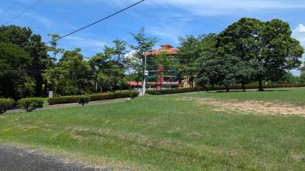 Wide landscaped grounds with mature trees and distant colonial style building at Punta Barco Resort Panama