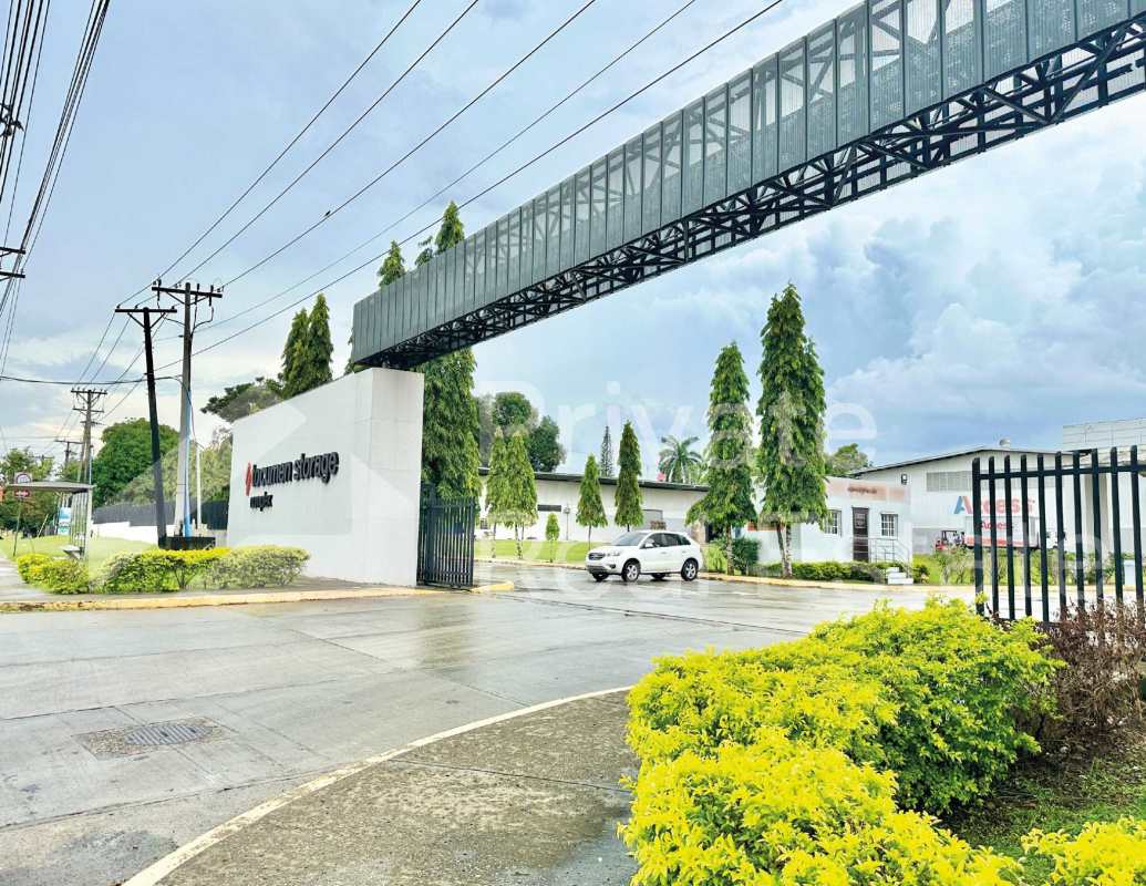 Industrial facility entrance with pedestrian bridge, signage and security gate Tocumen Panama