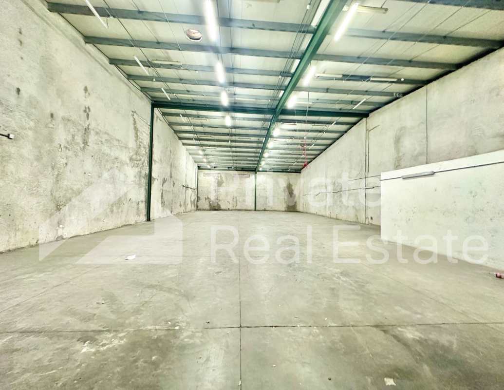 Industrial loading pavilion with wide driveway, multiple bays, and green landscaping