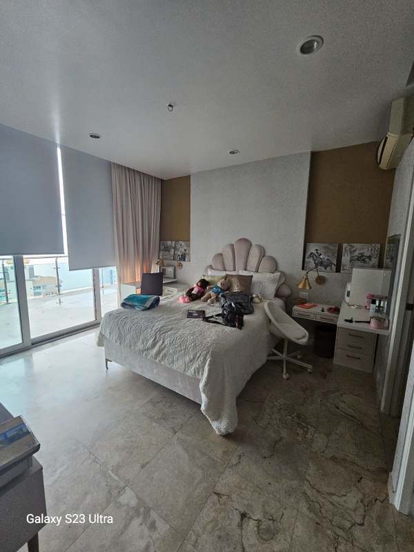 Spacious bedroom with marble floors, balcony access, large windows, shell headboard in PH Aqualina Tower Panama