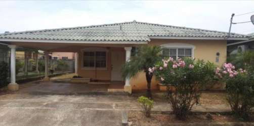 Single-story house with covered carport, hip roof and garden at Residencial Los Guayacanes Chitré Panama