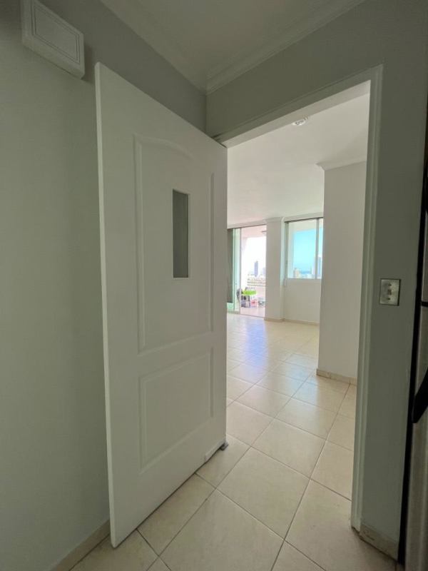Bright hallway and open plan living space with sliding doors to balcony in Panama apartment