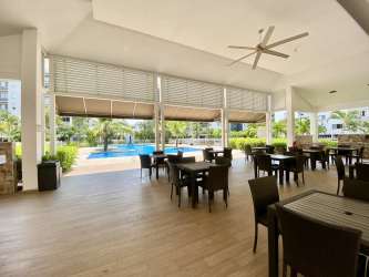 Covered outdoor dining lounge near pool area at PH Woodland Panama Pacifico
