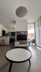 Open-plan living room with floor to ceiling windows kitchen view PH Mosaic Panama