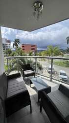 Balcony with seating and glass railing overlooking gardens at PH Mosaic Panama