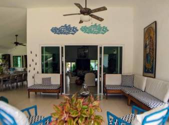 Spacious living area with high ceiling, tropical decor and large windows in Punta Barco Village