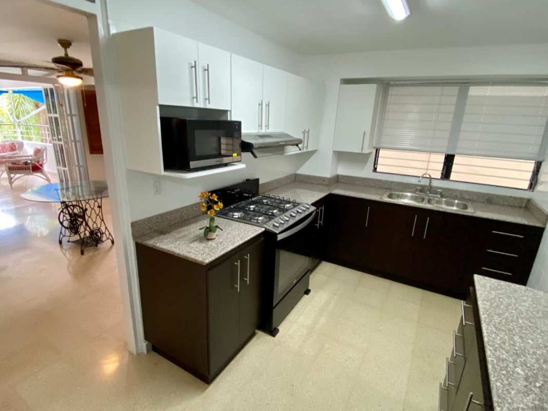 Modern kitchen with dark cabinetry, granite counters and appliances in PH Bella Vista Park Panama