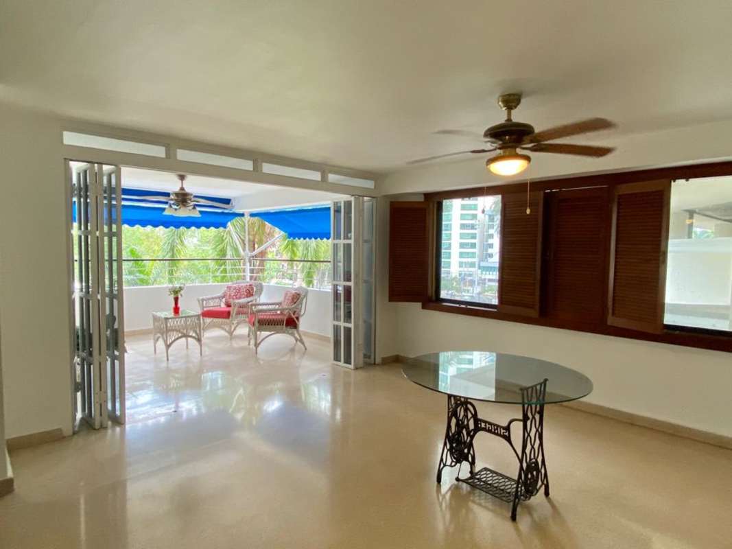 Living room with folding doors opening to terrace with park view in PH Bella Vista Park Panama City
