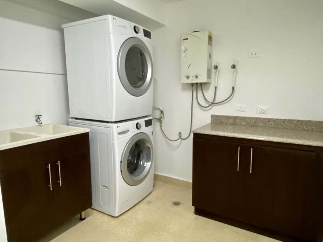 Laundry room with washer, dryer, and cabinets inside PH Bella Vista Park apartment for rent