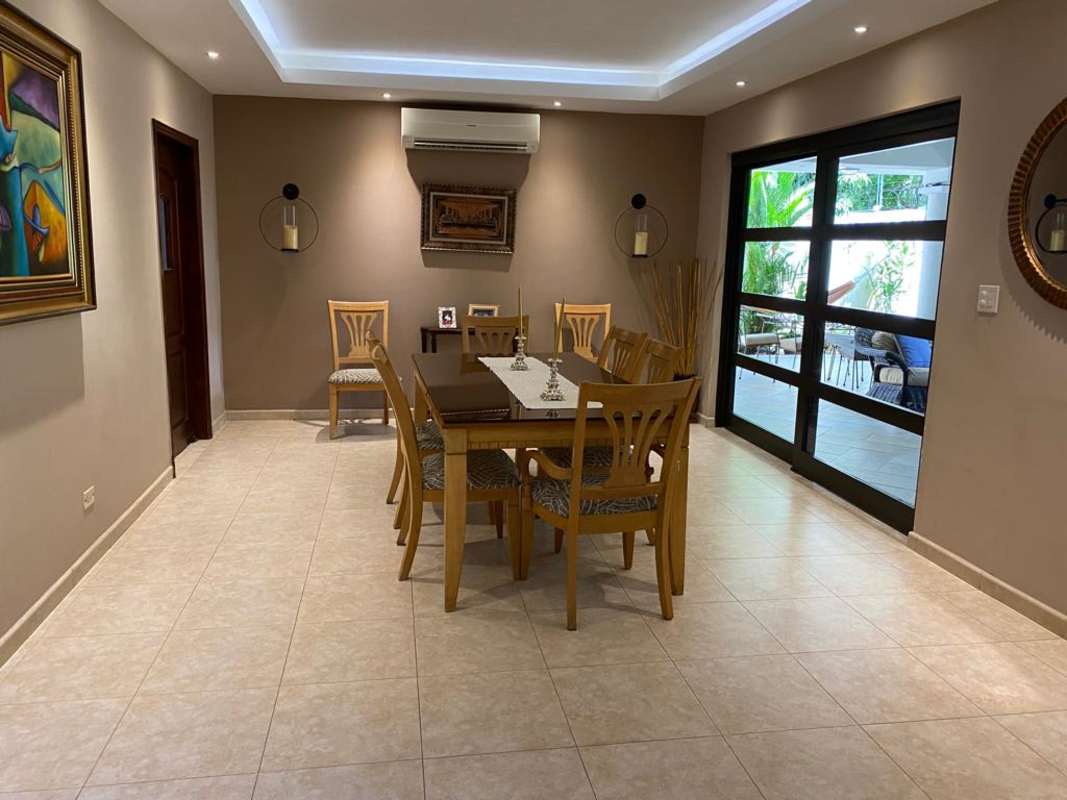 Dining room with wooden table, large glass doors and beige tile Palmeras del Este Costa del Este Panama