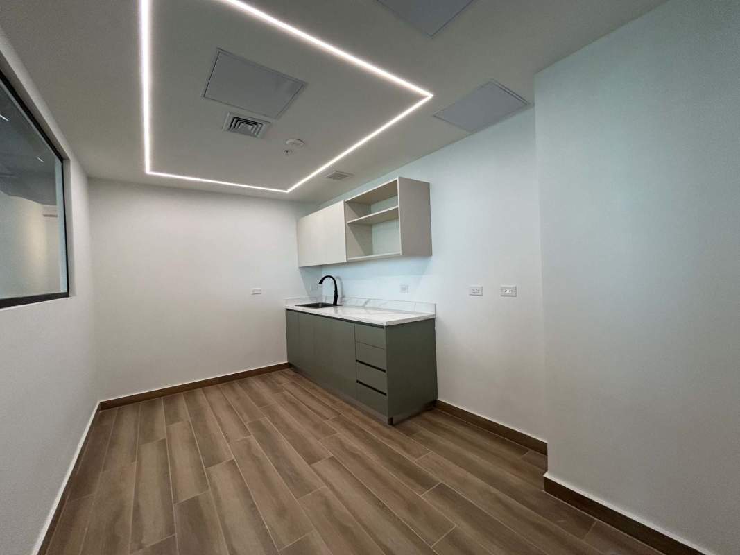 Modern kitchenette in office space with white cabinets, black fixtures Costa del Este Panama