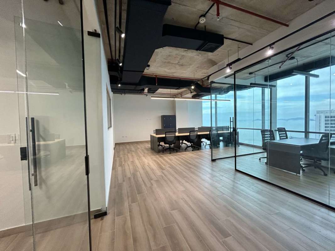 Bright modern office with glass walls, large windows, exposed industrial ceiling Costa del Este Panama