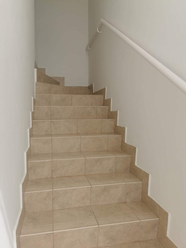 Upstairs bedroom with balcony access, tile flooring, and ample natural light Tocumen