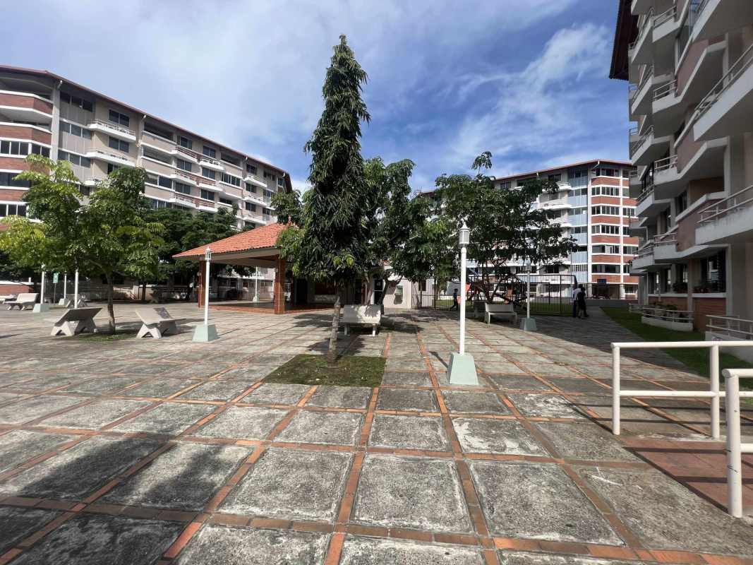 View of multi-story apartment tower with balconies inside secure Llano Bonito complex in Panama City