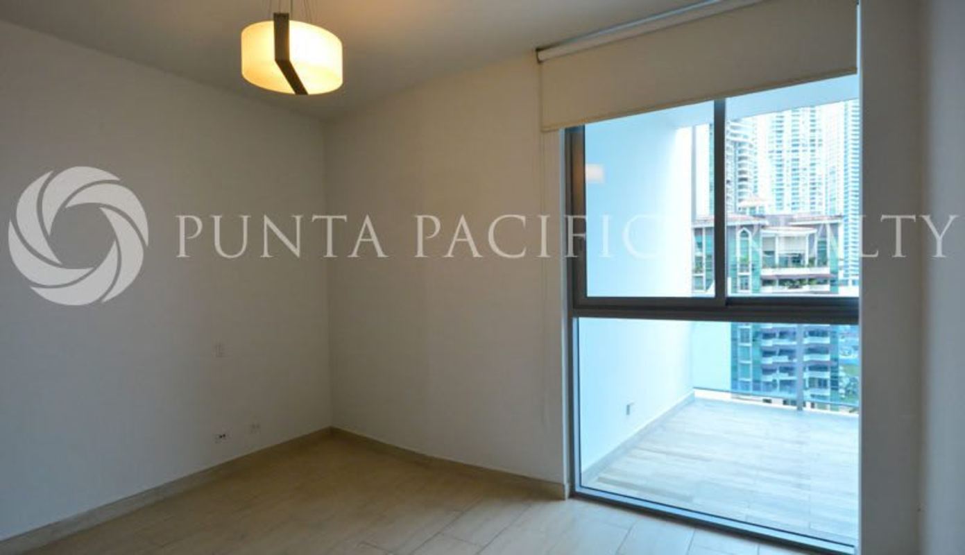 Bedroom with large window, balcony access, city skyline in Grand Tower Punta Pacifica Panama