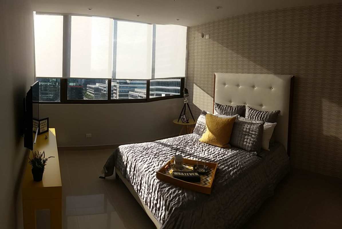 Bright bedroom featuring large windows, neutral tones, and urban views in PH Brisa Marina Panama