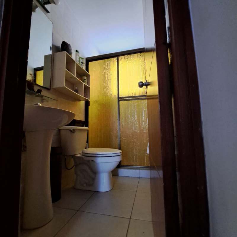 Small bathroom with storage cabinet, frosted shower, pedestal sink PH Central Park Panama