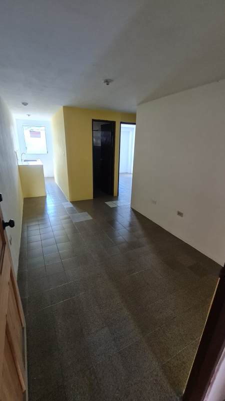 Empty bedroom with yellow and white walls featuring large louvered window in PH Morya Panama City