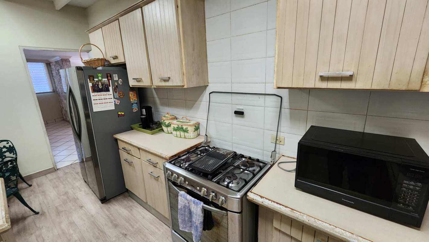 Traditional kitchen setup including gas stove microwave refrigerator in Marbella Panama