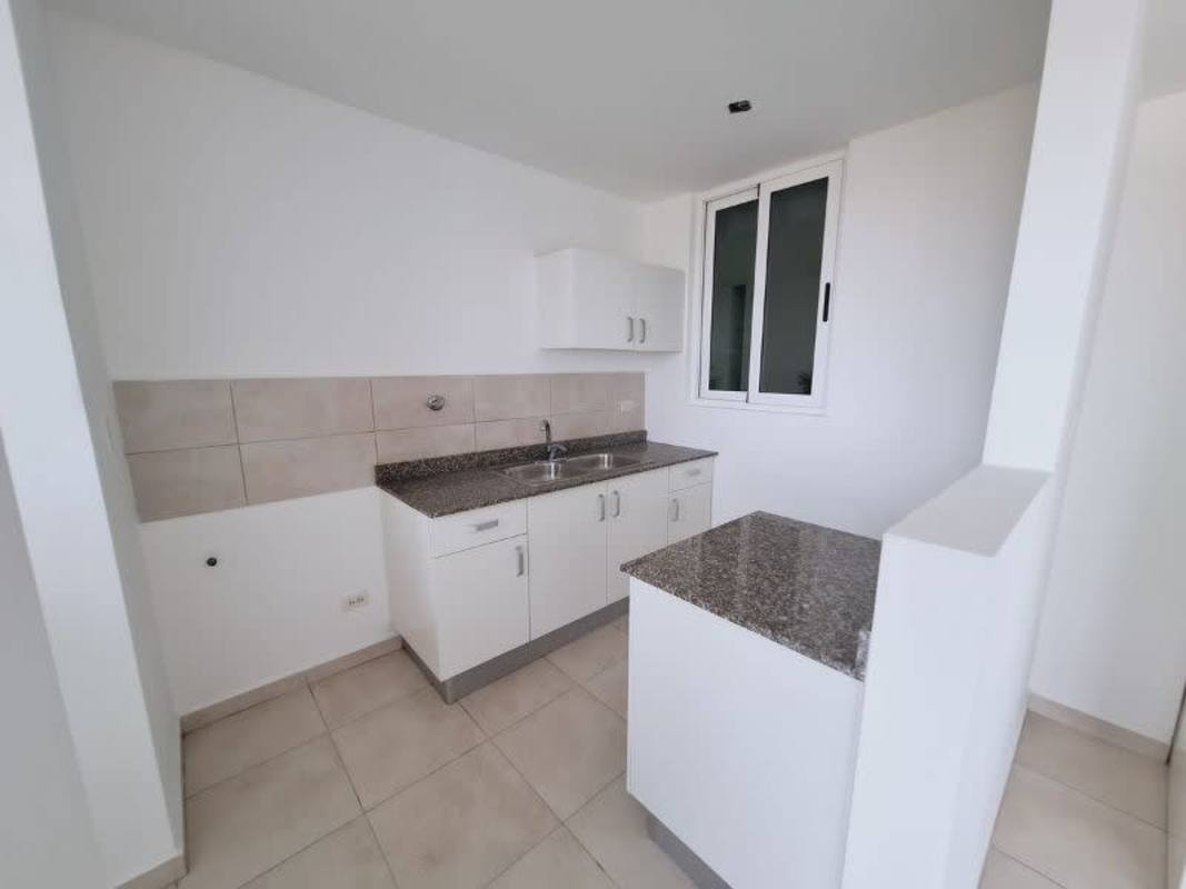 Apartment kitchen with granite countertops and white cabinetry at PH Mystic Valley Panama City