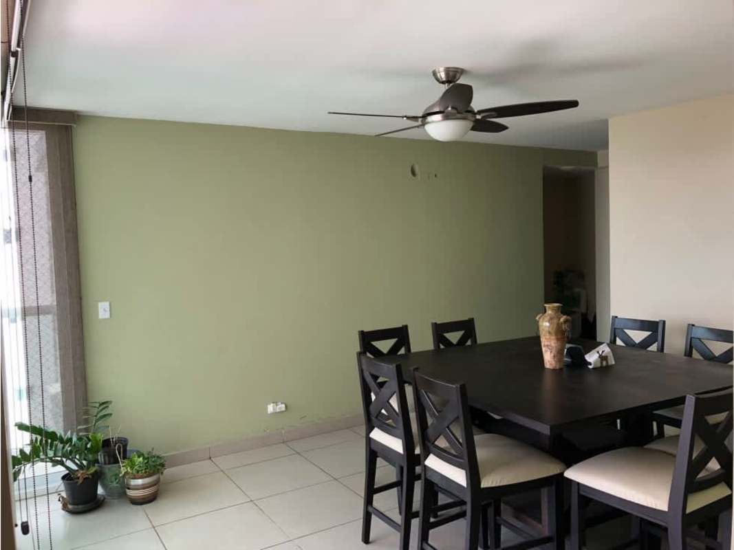 Large dining room with dark wood table, neutral walls, ceiling fan and natural light in PH Kings Park Condado del Rey Panama