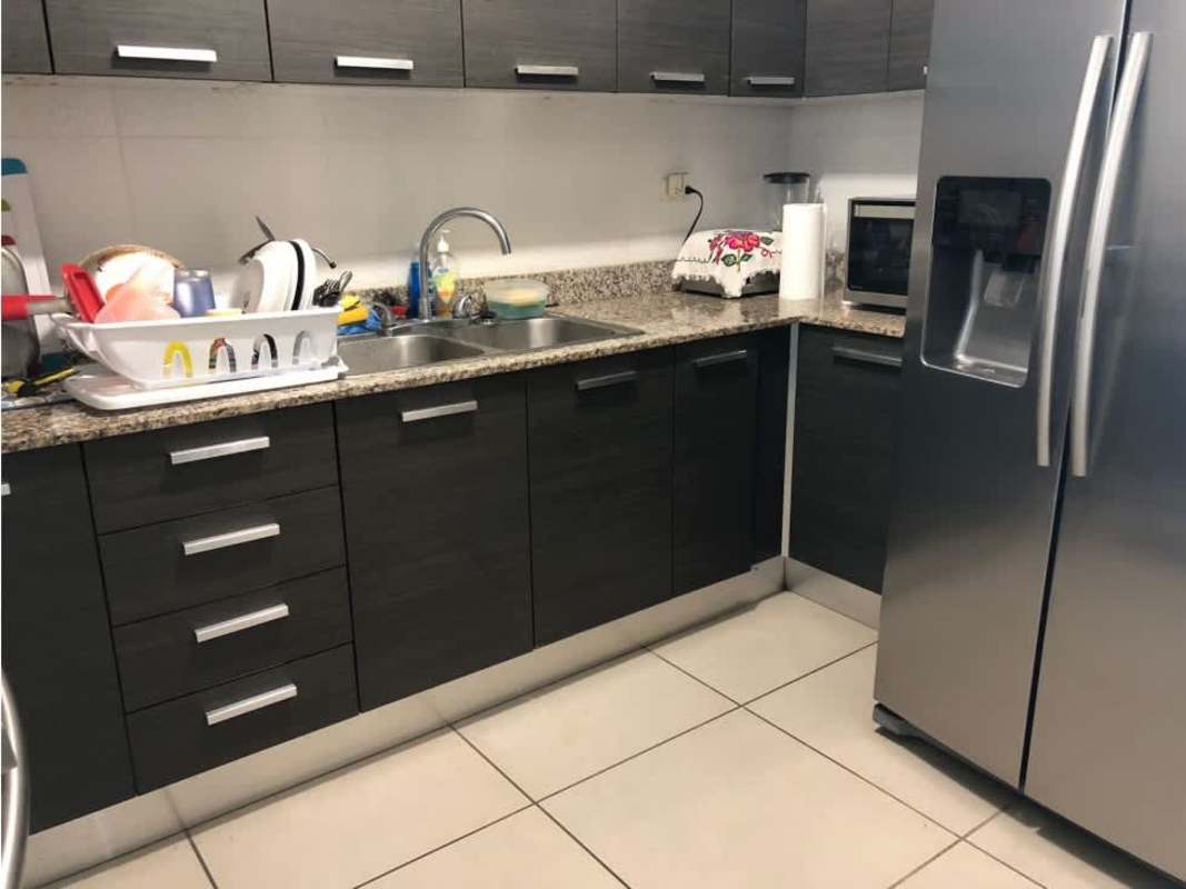 Modern kitchen with granite countertops, stainless steel appliances and dark cabinets in PH Kings Park Condado del Rey Panama