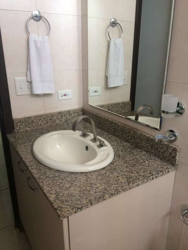 Modern bathroom with glass shower, granite vanity, tiled walls rental Panama