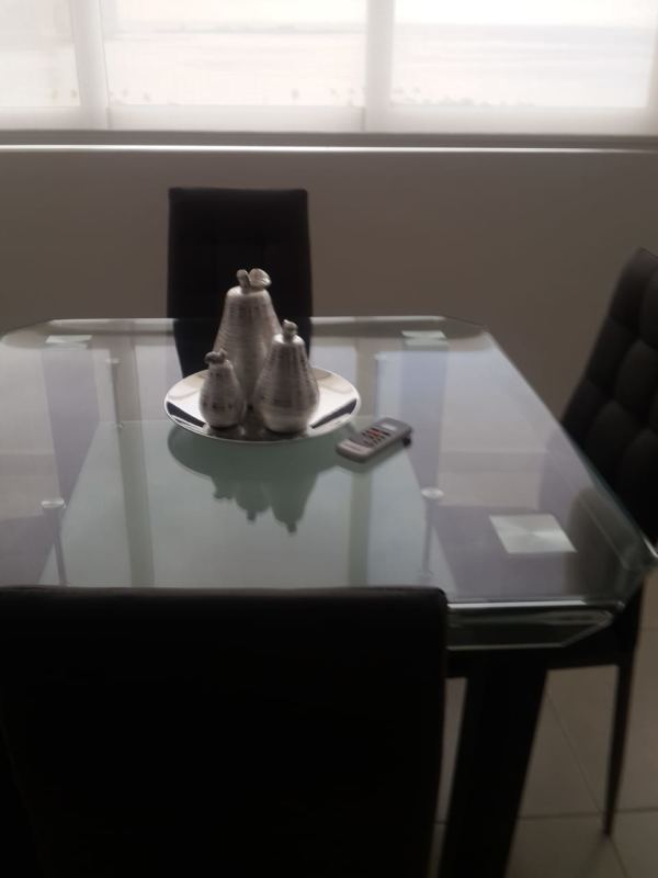 Modern dining with glass table, black chairs, large window ocean view apartment PH Bay View Panama