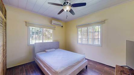 Bedroom with ceiling fan, large windows, wood floors in San José San Carlos Panama