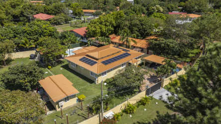 Aerial estate view with solar panels, multiple buildings, fenced yard in San Carlos Panama