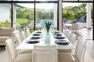 Modern covered dining patio overlooking swimming pool lush landscaping Punta Barco Village