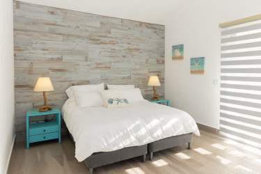 Spacious master suite with wood accent, terrace access and garden views Punta Barco