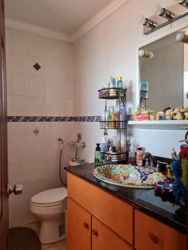 Spacious living and dining area with sectional sofa, chandeliers, and stairway Altos de Santa María Panama