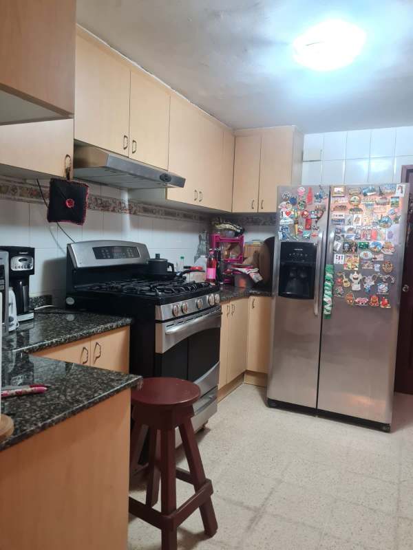 Large bedroom with king bed, patterned wallpaper, ceiling fan, mirrored wardrobe in house Altos de Santa María Panama