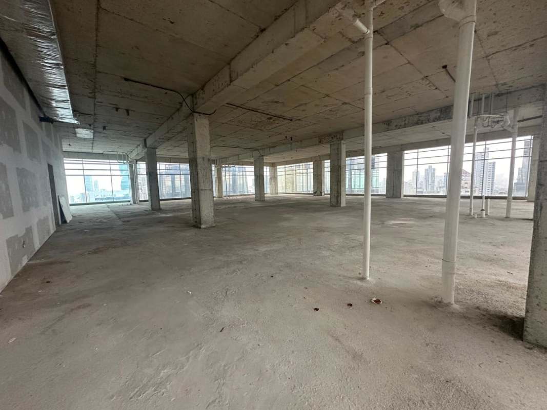 Panoramic unfinished open-plan office space in Sortis Business Tower with concrete finishes and city views