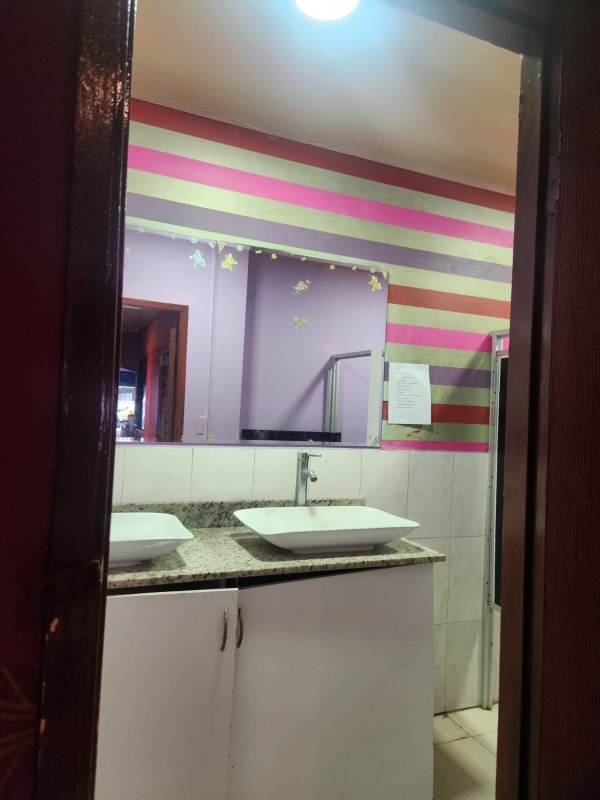 Restroom with urinals and blue walls inside commercial retail space at Gran Estación Panama